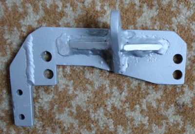 Engine head adapter. Connects to the Enfield frame with a rod, 25x115x5 mm piece of steel.<br />Made of 5 and 6 mm steel plate pieces, weight 0.4 kg.<br />The leftmost 2 holes are to fit the diesel filter