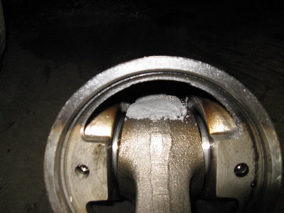 That's melted aluminum from the piston on the small end of the connecting rod.  There was more deposited on the cylinder wall.