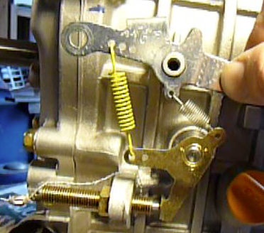 The engine speed ( fuel amount ) is controlled by an internal centrifugal  fuel regulator. The centrifugal  fuel regulator uses an external counterforce in terms of an applied spring force. The larger, yellow spring sets the applied force on the fuel regulator, more spring force is higher rev. at max. load. From the engine manual, I used the 3-B setting, inner hole on the top lever ( picture shows outer hole setting ) and second hole on the bottom lever.